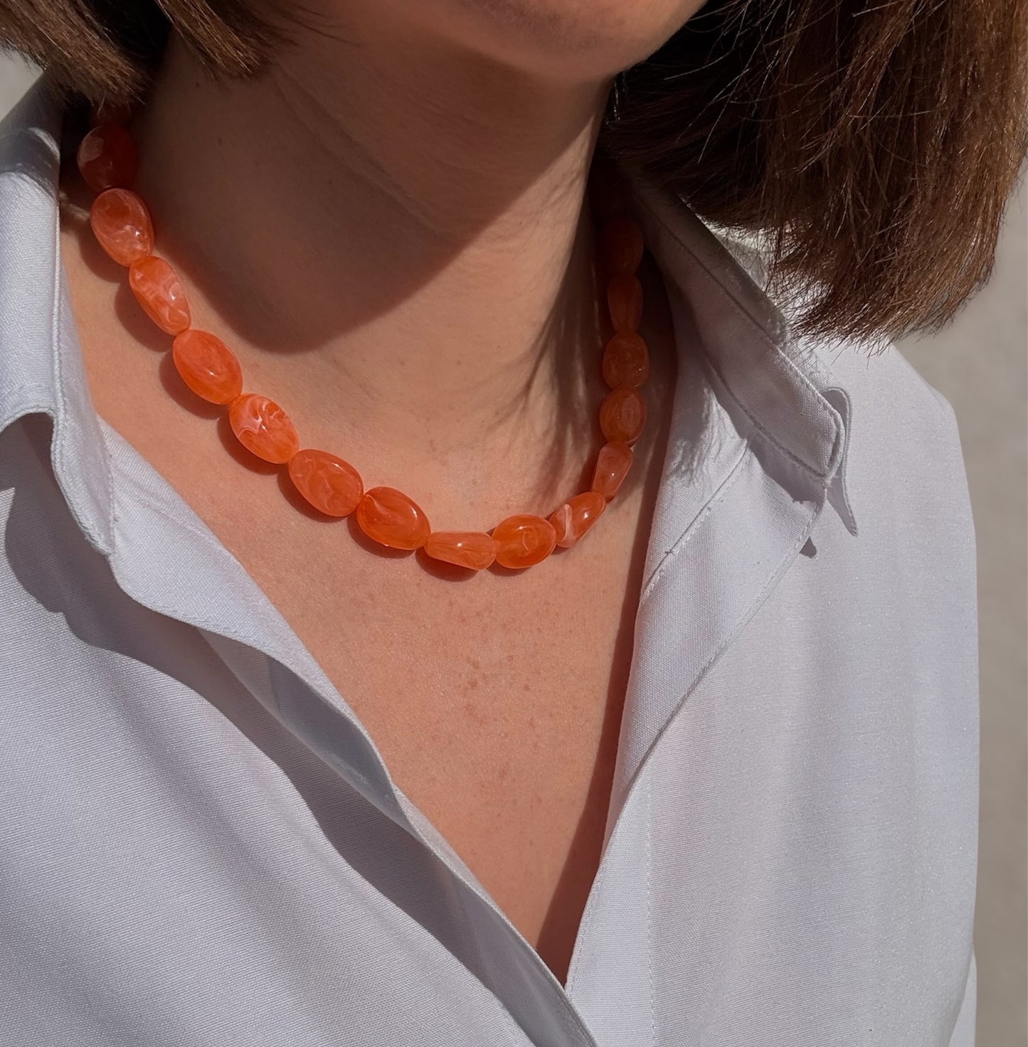 Collier Rivage orange porté avec fermoir doré discret à l'arrière