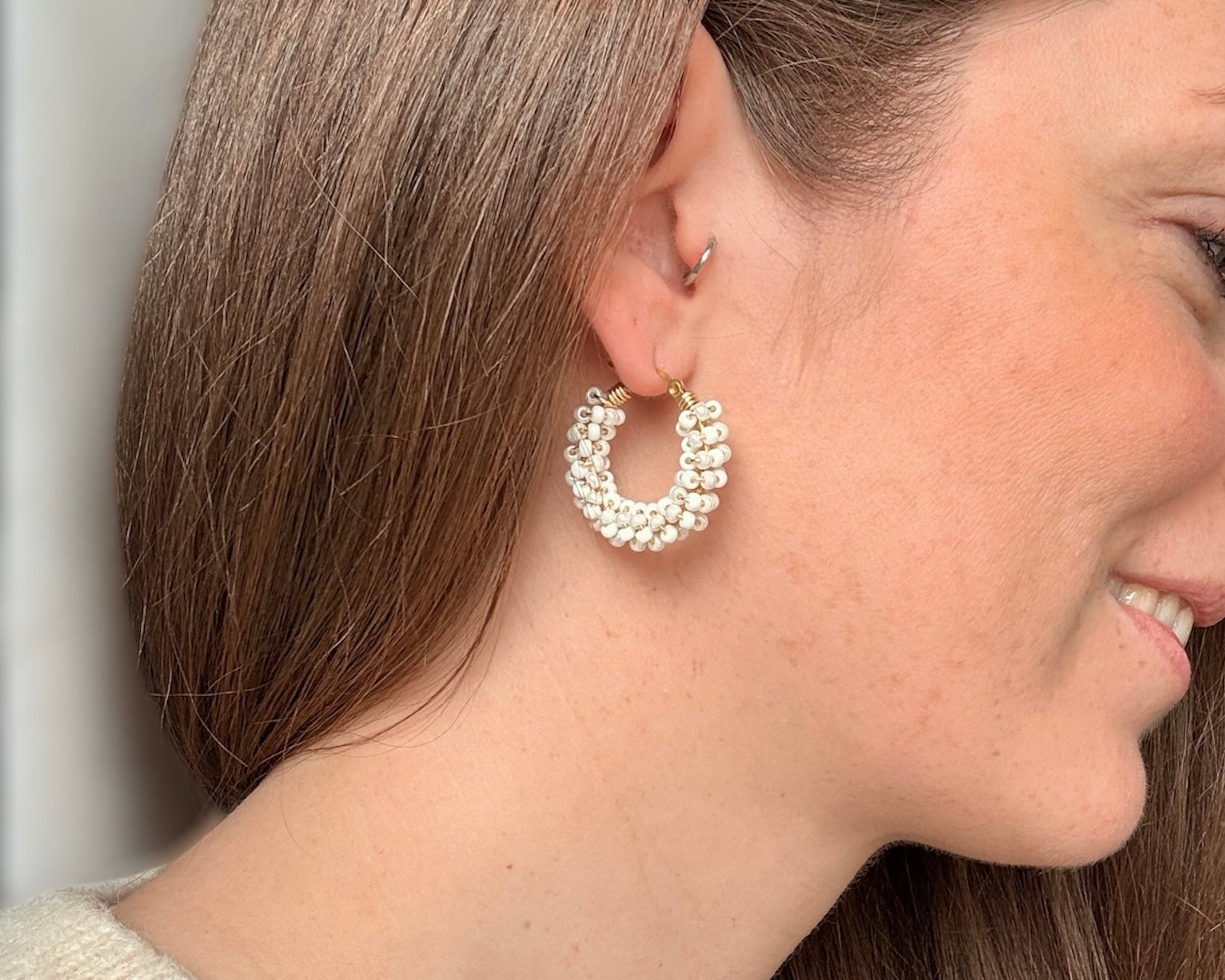 Boucles d'oreilles créoles Aura perlées en acier inoxydable, portées en Ivoire Doux