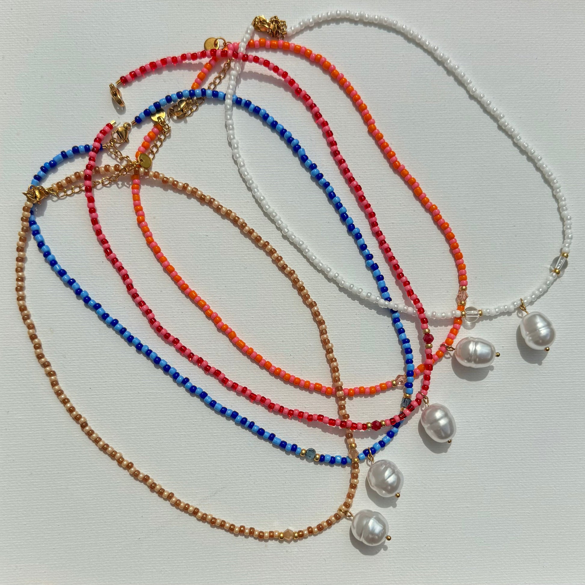 5 colliers Capri posés sur cadre 
