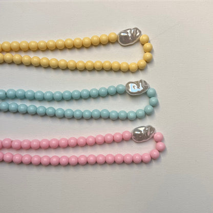 Collier Santorin rose, bleu et jaune pastel vue de dessus sur fond blanc